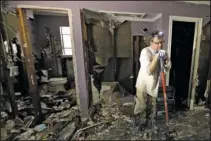  ?? The Associated Press ?? CLEANING UP: Edward Woods takes a break from cleaning up his mother's home, which was destroyed by floodwater­s in the aftermath of Hurricane Harvey Sunday in Spring, Texas.