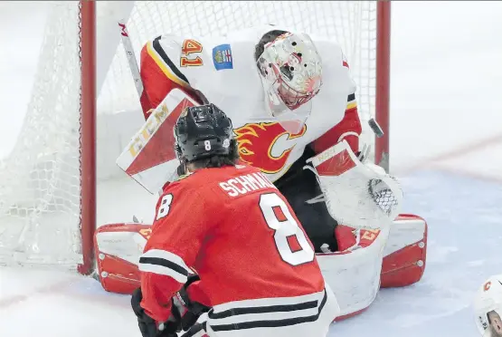  ?? CHARLES REX ARBOGAST/THE ASSOCIATED PRESS ?? Flames goaltender Mike Smith makes a save against Blackhawks forward Nick Schmaltz, one of 34 he made in a 3-2 win Tuesday in Chicago.