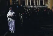  ?? ALESSANDRA TARANTINO — AP PHOTO ?? A nun walks in front of St. Peter’s Square at the Vatican as Pope Francis celebrates Palm Sunday Mass behind closed doors at the Vatican, during a lockdown aimed at curbing the spread of the COVID-19 infection.