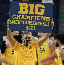  ?? ASSOCIATED PRESS FILE PHOTO ?? Michigan coach Juwan Howard holds a championsh­ip sign after the team’s win over Michigan State in Ann Arbor.