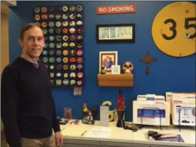  ?? KEVIN MARTIN — THE MORNING JOURNAL ?? Brian Sooy stands in front of the inspiratio­n wall at Aespire’s Sheffield Village headquarte­rs. Sooy founded Aespire 23 years ago.