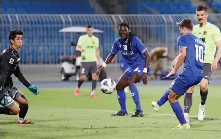  ?? AFP ?? Hilal’s forward Luciano Vietto, right, scores past AGMK’s goalkeeper Valijon Raximov during their AFC Champions League Group A match on Thursday.