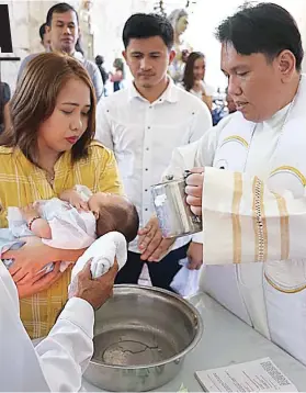  ?? / TAMPO ?? ■ GIBUNYAGAN: Mibubo sa balaang tubig si Padre Ruben Bajenting ngadto sa ulo ni Baby Ethan Xavier Patricio dihang kini gibunyagan sa St. Michael The Archangel Parish sa Argao niadtong Hunyo 23, 2018. Ang inahan sa bata nga si Diane Higida-Patricio...