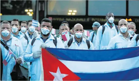  ?? FOTO: ANTONIO CALANNI/DPA ?? Einsatz im Kampf gegen das Coronaviru­s – und dringend benötigte Devisenque­lle für die heimische Regierung: Kubanische Ärzte und Fachleute bei der Ankunft am Flughafen Mailand-Malpensa.