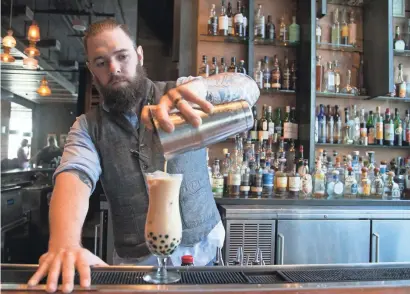  ?? PHOTOS BY DAVID WALLACE/THE REPUBLIC ?? Clark of Blue Hound Kitchen and Cocktails at the Hotel Palomar in downtown Phoenix tops tapioca pearls with a mixture of tea-infused vodka, coconut milk, chai vermouth and cinnamon syrup to make the “Boba Tea” cocktail.