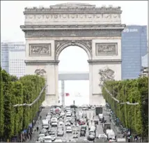  ?? FRANCOIS MORI / ASSOCIATED PRESS ?? Cars drive Monday along the Avenue des Champs-Elysees, with the Arc de Triomphe in the background, as clothiers, coiffures and other businesses large and small reopen and the French begin leaving their homes for the first time in two months.