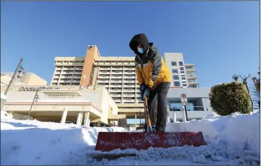  ?? (Arkansas Democrat-Gazette/Thomas Metthe) ?? Jeff Echols, director of engineerin­g at the Doubletree Hotel in downtown Little Rock, shovels the driveway of the hotel on Tuesday.