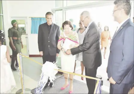  ?? (Ministry of the Presidency photo) ?? President David Granger assisting First Lady, Sandra Granger in the ceremonial ribbon-cutting to officially declare open, Republic Bank’s Triumph Branch. They are flanked at left by Chairman of Republic Bank, Nigel Baptiste and Managing Director...