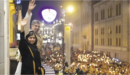  ?? FREDRIK VARFJELL / AFP / GETTY IMAGES ?? Nobel Peace Prize laureates Malala Yousafzai, left, and India’s Kailash Satyarthi wave from the balcony of the Grand Hotel ahead of the Nobel banquet in Oslo in December of 2014.