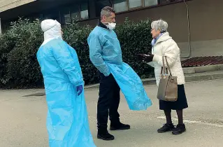  ??  ?? Un’infermiera e un vigilantes del pronto soccorso di Torregalli, vestiti con le tute protettive, aspettano fuori dall’edificio le persone in arrivo
