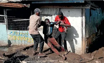  ?? PHOTO: REUTERS ?? Opposition supporters carry a protester injured during clashes with police in Kibera slum in Nairobi.
