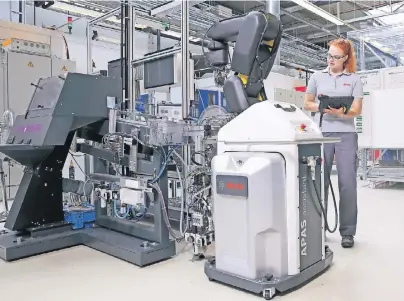  ?? FOTO: BOSCH ?? Laura Kästner, die eine Ausbildung zur Elektronik­erin für Automatisi­erungstech­nik macht, lernt auch, wie Roboter programmie­rt und bedient werden. Hier steuert sie einen Arbeitsrob­oter im Bosch-Werk Homburg über ein mobiles Touchpad an.