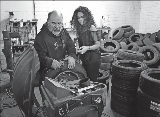  ?? [JONATHAN QUILTER/DISPATCH PHOTOS] ?? Sariah Brady, 18, works with Troy Gallagher, her mother’s fiance, on balancing a tire in the family’s auto-repair shop in Danville. Sariah enrolled in the automotive-technology program at the Knox County Career Center and graduated from high school...