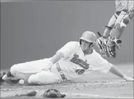  ?? Gus Ruelas Associated Press ?? CODY REGIS of UCLA slides home on a double by Kevin Kramer in the second inning against Creighton. The Bruins scored all their runs in the first two innings.