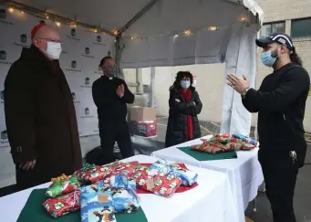  ??  ?? TALKING THINGS OVER: From left, Cardinal Sean O’Malley, Father John Unni and Lyndia Downie, president and executive director of the Pine Street Inn, talk with a resident of the Pine Street Inn on Christmas Eve.