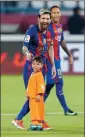  ?? AGENCE FRANCE-PRESSE ?? Left: Lionel Messi talks to Afghan boy Murtaza Ahmadi on the pitch before a friendly soccer match in 2016 in Qatar. Right: Ahmadi kicks stones outside his home in Kabul on Monday.