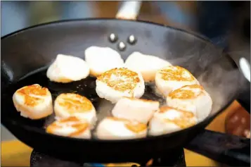  ?? TRIBUNE CONTENT AGENCY ?? Briefly sear the scallops before coating them in the teriyaki glaze.