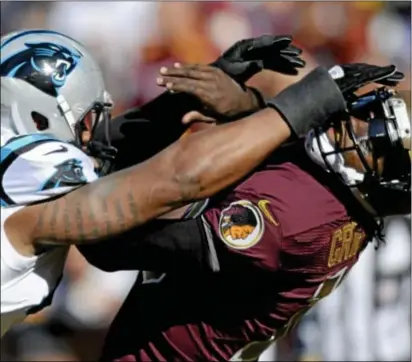  ?? Associated Press ?? Redskins quarterbac­k Robert Griffin III has had a successful rookie season, but not all moments have been as smooth, as Carolina defensive end Greg Hardy, left, showed him in a recent game.