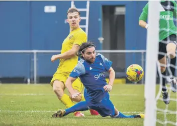  ??  ?? Dan Jarvis (yellow) scores his third goal for Peterborou­gh Sports at Bedford Town. Photo: James Richardson.
