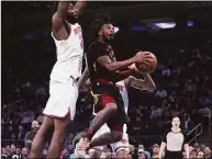  ?? Bebeto Matthews / Associated Press ?? Cleveland Cavaliers guard Darius Garland, right, goes for basket against the New York Knicks during the first half on Saturday in New York.