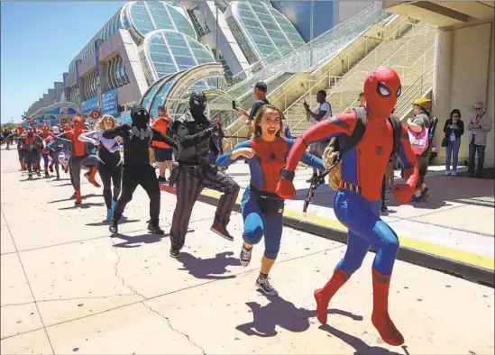  ?? Photograph­s by Hayne Palmour IV San Diego Union-Tribune ?? COMIC-CON attendees ham it up as various characters of the Spider-Verse for the filming of a YouTube video Saturday in front of the San Diego Convention Center.