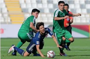 ?? Photo by Ryan Lim ?? Japan’s Yuya Osako is brought down to the ground as he attempts to dribble past Turkmenist­an’s Mingazov Ruslan (left) and Amanov Arslan during a Group F match. —