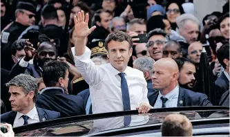  ?? REUTERS ?? EMMANUEL Macron waves as he leaves after a visit at the Saint-Christophe market square in the Paris suburb of Cergy, on Wednesday, as part of his first trip after being re-elected as president of France on Sunday. |