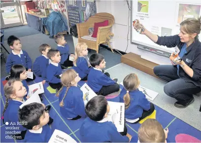  ??  ?? An RSPB worker reaches children