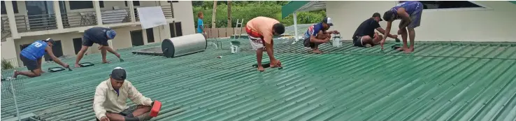  ??  ?? The K9E brothers work on the rooftop of a home in Suva.