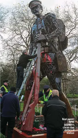  ??  ?? Red paint: OPW workers clean the defaced statue
