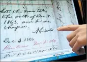  ?? ANTONIO PEREZ/ TRIBUNE NEWSPAPERS PHOTO ?? A researcher points out Abraham Lincoln’s signature on a document at his presidenti­al library in Springfiel­d, Ill.