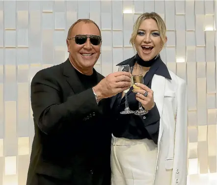  ??  ?? Fossil Group markets the work of designer Michael Kors, pictured with actor Kate Hudson.