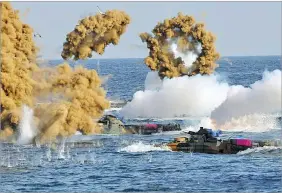  ??  ?? South Korean amphibious assault vehicles fire smoke shells during a landing operation in the southern city of Pohang. YONHAP/AFP