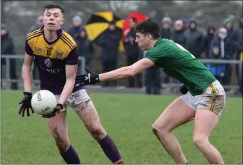  ??  ?? Colum Feeney gets a handpass away despite the pressure exerted by Meath midfield Daithí McGowan.