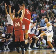  ?? Yong Kim / Philadelph­ia Daily News ?? As Villanova’s Jalen Brunson misses a desperatio­n shot, Wisconsin players begin to celebrate.