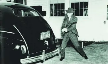  ?? FORD MUSEUM / GREENFIELD VILLAGE AND FORD MOTOR COMPANY ?? Henry Ford, who toyed with compressed soybeans to produce plastic-like components,
strikes a composite trunk lid with a sledgehamm­er to demonstrat­e its strength.