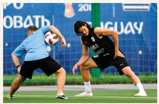  ??  ?? PHOTO AFP Edinson Cavani a effectué des exercices d’étirement avec un thérapeute de l’équipe de l’uruguay, hier. Sa présence dans la formation est incertaine ce matin.