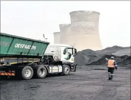  ?? PHOTO: BLOOMBERG ?? A worker oversees a truck delivering coal supplies to Grootvlei power station, which is operated by Eskom. Renewable energy is viewed as a major threat to jobs in mining and transport.