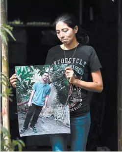  ?? FOTO: AFP ?? Sandra Hernández muestra una foto de su esposo, José Medrano, quien murió tras ser detenido durante el régimen de excepción.