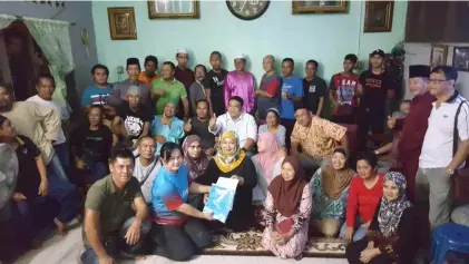  ??  ?? Voon (front, second left) hands over the Keadilan t-shirts to Surati as a gesture to welcome her as Batu Kitang sub-branch Women chief as well as new members to the party.