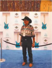  ??  ?? Mitchell Cypress, vice chairman of the Seminole tribal council, stands in front of a guitar display at the Seminole Hard Rock Hotel and Casino last week.