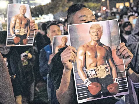  ??  ?? Pro-democracy protesters in Hong Kong hold posters of Donald Trump superimpos­ed on to Rocky Balboa after the president supported the activists