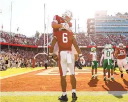  ?? EZRA SHAW GETTY IMAGES ?? Stanford receiver Elijah Higgins (6) is congratula­ted by Tucker Fisk after making the tying touchdown catch at the end of the fourth quarter against Oregon.