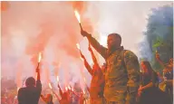  ?? ?? Soldados sostienen bengalas durante el funeral del activista y soldado Roman Ratushnyi, en Kiev, Ucrania.