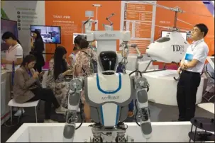  ?? The Associated Press ?? HIGH-TECH EXPO: Visitors to the 21st China Beijing Internatio­nal High-Tech Expo look at robots and helicopter drones displayed in Beijing, China, on Thursday. The Trump administra­tion has threatened to impose tariffs on up to $150 billion in Chinese...