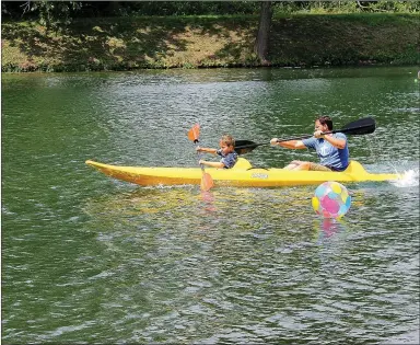  ?? MEGAN DAVIS/MCDONALD COUNTY PRESS ?? Nine-year-old Ian Ruby and his father maneuver around beach balls during Honey Creek kayak races on Saturday, June 18. Contestant­s paddled to the end of the lake at Blankenshi­p Park, through the balls, and across the finish line.