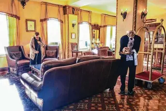  ?? Billy Calzada / Staff photograph­er ?? Emma Rose sweeps at the Faust Hotel, 240 S. Seguin Ave. in New Braunfels, as a character that some refer to as Walter Faust, who opened the hotel in 1929, stands by with a skull on a tray.