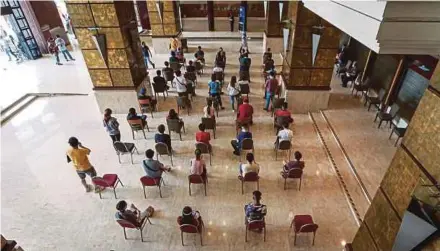  ?? PIC BY AZIAH AZMEE ?? People waiting to get vaccinated at a vaccinatio­n centre in Kuala Lumpur yesterday.