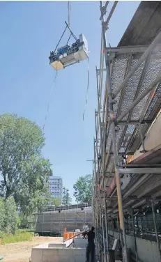  ?? FOTO: GWG KOMMUNAL ?? Gestern Mittag hievte ein Kran das vier Tonnen schwere Blockheizk­raftwerk für das neue Schlossbad auf seinen Platz.