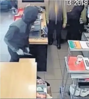  ??  ?? CCTV footgae shows the masked man carrying the blade and moving behind the counter